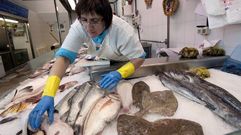 En el centro, a la altura de la mano de la pescadera, un besugo, en una foto de archivo de un puesto de la plaza de abastos de Viveiro