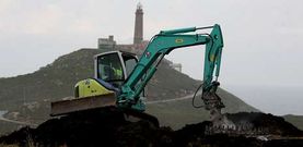 Una excavadora retira una de las zapatas de los aerogeneradores, frente al faro de Cabo Vil�n. 