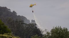 Helic�ptero durante las labores de extinci�n del incendio forestal en Grado, Asturias