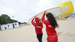 Dos socorristas este s�bado, una de las pocas jornadas en las que el calor dio un respiro, en la playa de Caranza, donde m�s rescates se registran, con la tabla que utilizan para las tareas de salvamento.