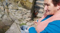 Una vecina recoge agua en una fuente en Santiago de Castill�n