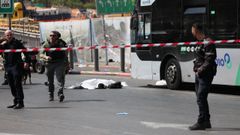 Agentes de la polica en la zona donde se produjo el tiroteo, con un cadver en el suelo