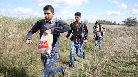 PASO H�NGARO. Los menores sirios de Alepo Raqq�n y Mohanad (primero y tercero) corren para evitar los controles en el puesto fronterizo h�ngaro de Roszke.