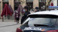 Agentes de la Polic�a Nacional vigilan en una plaza del centro de Monforte que los transe�ntes cumplan las restricciones anticontagio que entraron en vigor este mi�rcoles