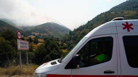 Una ambulancia entra este jueves, en Genestoso (Cangas del Narcea), mientras un incendio afecta a la zona
