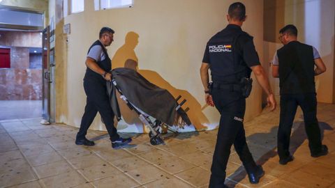 Traslado de uno de los cuerpos en la entrada del edificio de Benalm�dena