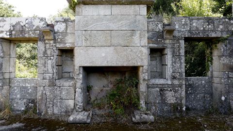 La chimenea del pazo do Casal, con maleza a su alrededor y evidenciando la carencia de techo.