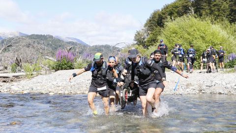 El equipo, formado por 17 corredores, sujetando las sillas para cruzar el r�o en uno de los momentos del recorrido.