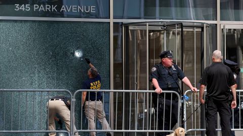 Investigadores de la NYPD inspeccionan un agujero de bala en el lugar del tiroteo.