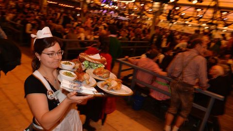 Una camarera con varios platos tradicionales durante la apertura de la Oktoberfest en Munich (Alemania)