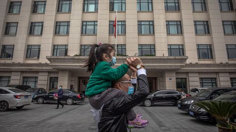 Un hombre lleva en hombros a una ni�a en la ciudad china de Wuhan