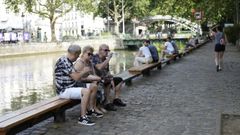 Varias personas descansan del calor a orillas del Sena