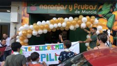 Pili Moreda emocionada con la despedida organizada por todos sus vecinos y clientes, mientras sujeta uno de los grandes carteles al nombre de �Te queremos Pili�.