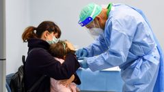 Un m�dico administra una vacuna contra la gripe a un ni�o en Mil�n.