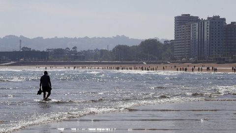Los gijoneses aprovechan el buen tiempo para pasear por la playa de San Lorenzo