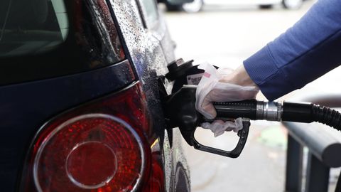 Una persona reposta carburante en una gasolinera.