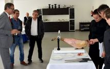 El alcalde y dos asistentes observan las lecciones de corte de jam�n. 