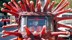 Un hombre conduce un veh�culo que simula un viros para alertar de la peligrosidad del coronavirus en La India