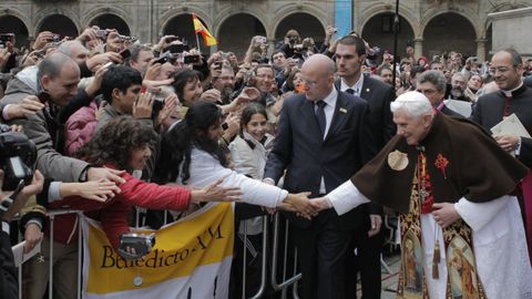 El papa Benedicto XVI vestido de peregrino, una capa con la concha de vieira y la Cruz de Santiago, saluda a las personas congregadas en la plaza de la Quintata antes de cruzar la Puerta Santa de la Catedral de Santiago de Compostela.