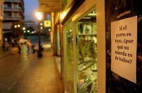 La campa�a de carteles para denunciar la pr�ctica de los perros aumenta entre el comercio de Lal�n.