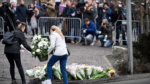 Dos de las personas que dejaron flores en la zona donde se produjo el incendio