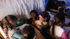 Nenas sirias desprazadas nun campamento para refuxiados asisten a clase