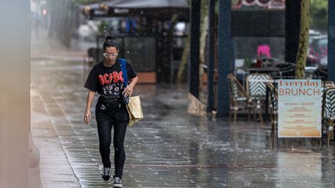 Una ciudadana anda bajo la lluvia en Madrid. La capital de Espa�a est� en alerta roja por chubascos y tormentas, y el Ayuntamiento recomienda no salir de casa y evitar el uso de veh�culos.