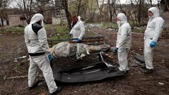 Un equipo de emergencias retiran un cuerpo que yace en un banco en Mari�pol.