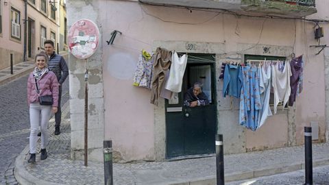 Unos turistas descienden hacia la r�a Oliveira do Carmo, en Lisboa, una calle donde las viviendas tur�sticas cercan a la poblaci�n local. 