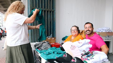 Irene Mart�nez y Sergio Rodr�guez, de la comisi�n de fiestas de Caranza, este s�bado en el puesto de �merchandising� instalado en el mercado.