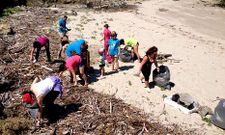 En la imagen, un grupo de voluntarios retirando ayer restos de basura del arenal ceense de Lires. 