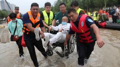 Equipos de rescate evac�an a una persona en silla de ruedas en la ciudad de Zhengzhou