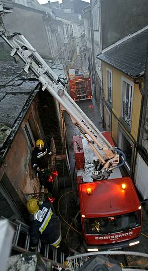 Bomberos en la extinci�n del fuego en el 45 de la R�a Nova.