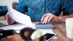 Una persona hace cuentas con una calculadora.