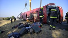 Los servicios de rescate tratando de remolcar el autocar siniestrado