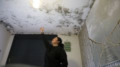 Elena Loureiro, en su dormitorio con el techo y las paredes cubiertos de moho.