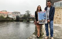 Rosa y Alfonso sostienen el cartel de las celebraciones con el puente de su pueblo al fondo<span lang= gl >. </span>