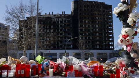 Flores, velas y peluches colocados como homenaje ante el edificio incendiado en el barrio del Campanar de Valencia hace una semana