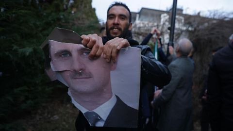 Un ciudadano sirio partidario de la oposicin rompe una foto del dictador Bashar al-Asad en Damasco.