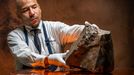 Un trabajador de la casa de subastas sostiene la roca de origen marciano