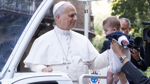 El papa bendiciendo a un beb� en su camino hacia la Sagrada Familia.