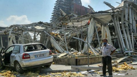 Un guardia de seguridad delante de la sala de exposicin de Audi Motor destruida por la explosin