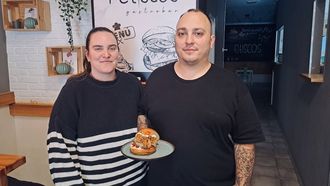 Antía Cidre y Juan Tocino posan en el comedor del Petiscos junto a «Orixe2016», la hamburguesa que se acaba de coronar como la segunda mejor de Galicia.