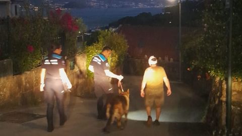 Uno de los dos heridos, el que pudo llamar para avisar y montar el dispositivo de rescate, es acompañado junto a su perro por los agentes hasta la ambulancia