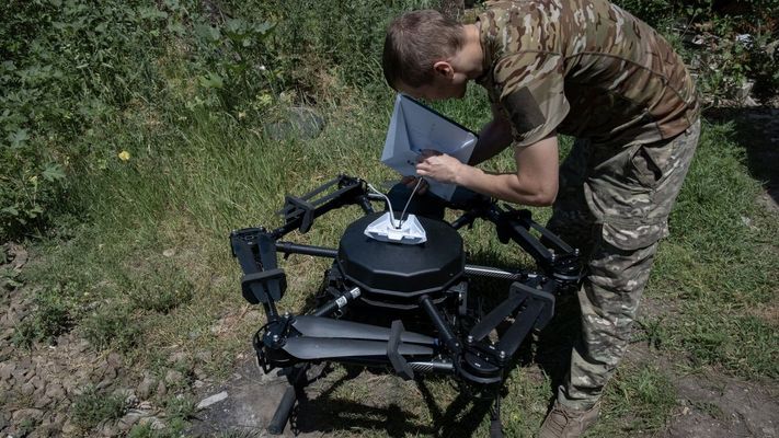Un soldado ucraniano carga un dron con combustible.
