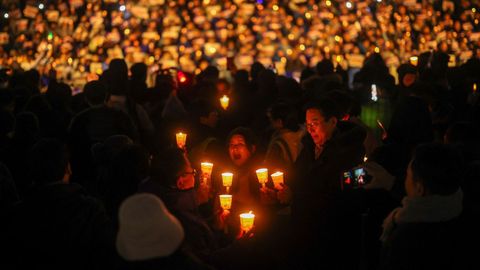 Varias personas sujetan velas encendidas en una concentracin para exigir la dimisin del actual presidente de Corea del Sur, Yoon Suk-yeol