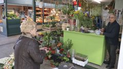 El florista Julio P�rez atend�a a una clienta, el lunes por la ma�ana, en su puesto del mercado municipal