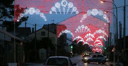 Los arcos de luz y una fuente luminosa adornan la PO-549 con motivo de las fiestas patronales. 