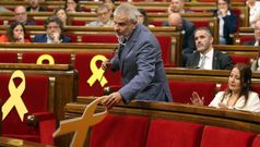 Momento en el que Carlos Carrizosa retira un lazo amarillo colocado en el banco del Govern