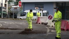 Un obrero limpia la calzada al final del turno de ma�ana de la primera jornada de trabajo en el cruce de B�veda
